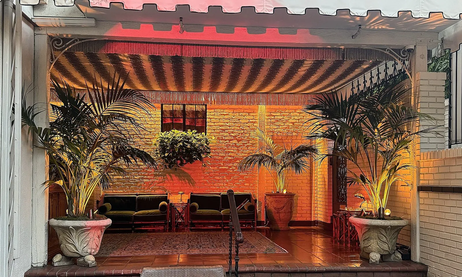 Warm covered courtyard with red awning at an estate event