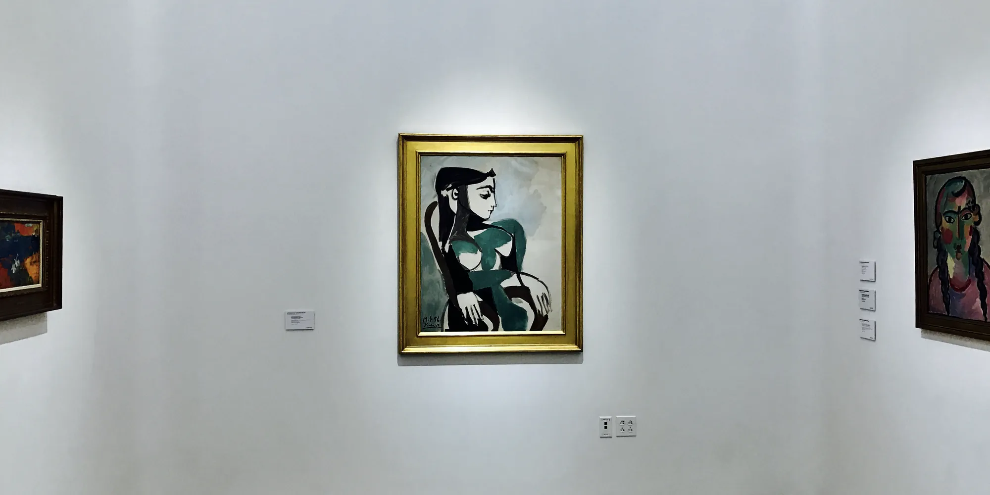 A framed painting centered on a white gallery wall at Christie's in Beverly Hills