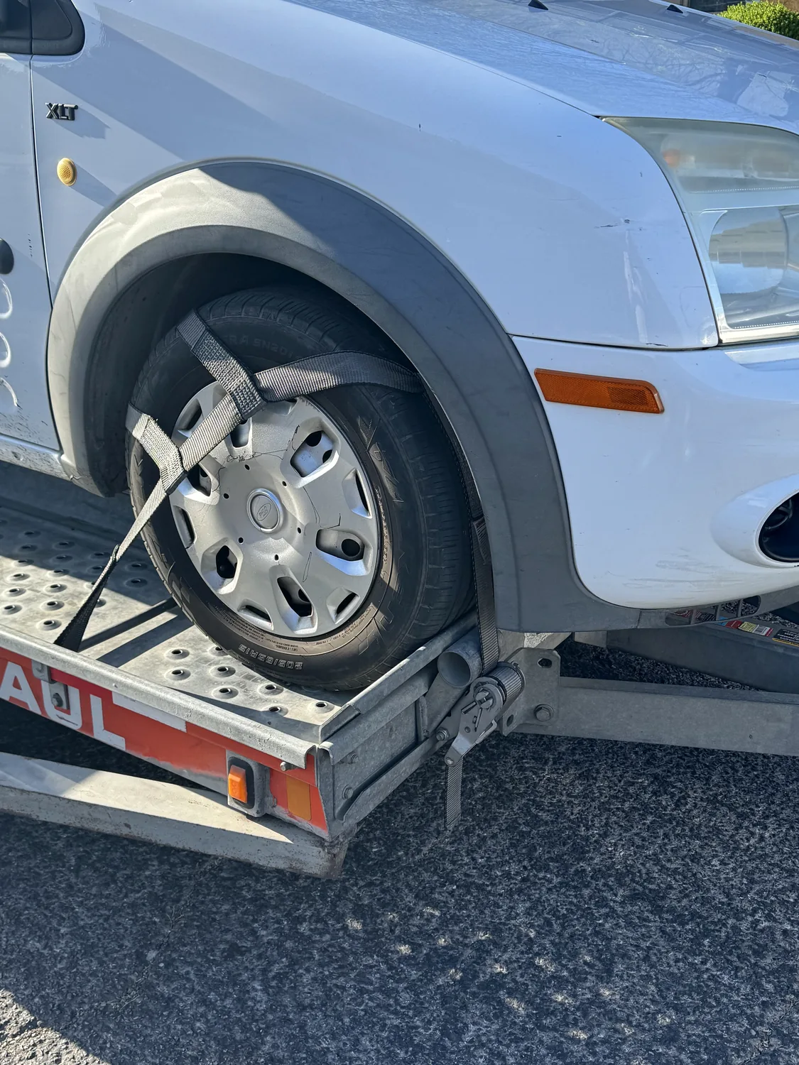 Close-up of the AVE work van strapped down on the trailer for the tow home